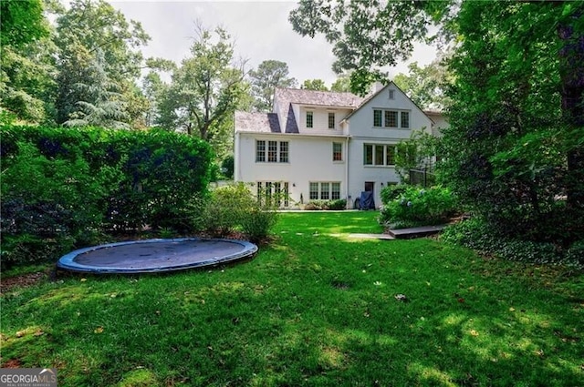 510 Heards Ferry Rd, Atlanta, GA 30328 - back of house featuring a trampoline, a lawn, and stucco siding