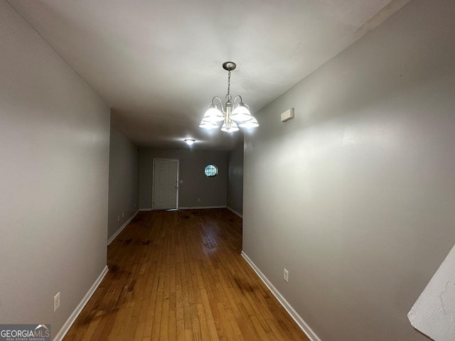 1017 Wheel House Ln Unit D, Monroe, GA 30655 - unfurnished dining area featuring wood-type flooring and a chandelier