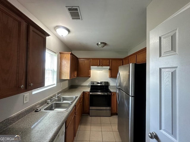 1017 Wheel House Ln Unit D, Monroe, GA 30655 - kitchen featuring appliances with stainless steel finishes, under cabinet range hood, light tile patterned floors, and brown cabinets