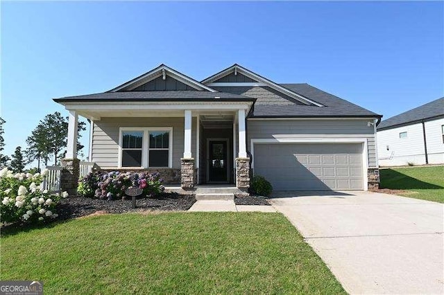 1057 Towne Mill Xing, Canton, GA 30114 - craftsman house featuring an attached garage, concrete driveway, a front yard, and stone siding