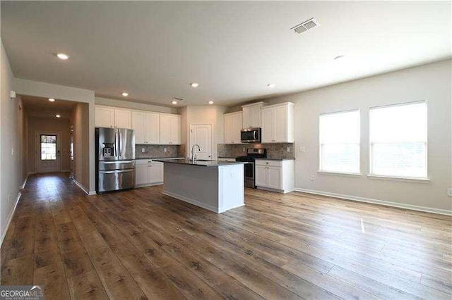 1057 Towne Mill Xing, Canton, GA 30114 - kitchen with appliances with stainless steel finishes, dark countertops, decorative backsplash, white cabinets, and recessed lighting