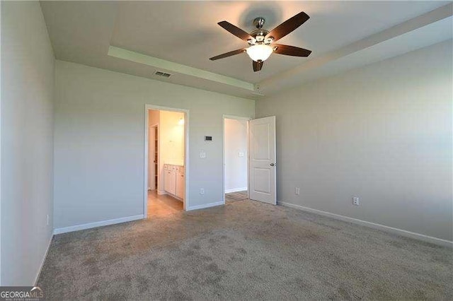 1057 Towne Mill Xing, Canton, GA 30114 - unfurnished bedroom featuring a raised ceiling, carpet, ensuite bathroom, and a ceiling fan