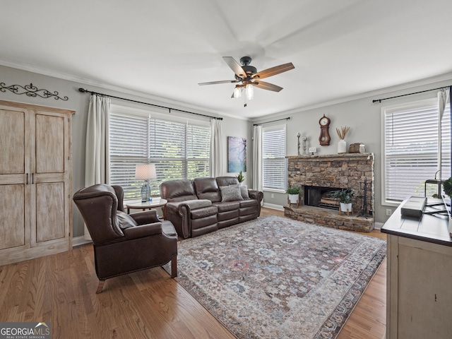 302 Thornhill Cir, Jefferson, GA 30549 - living room featuring a ceiling fan, ornamental molding, plenty of natural light, wood finished floors, and a stone fireplace