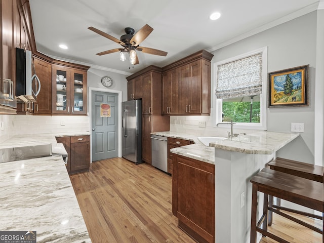 302 Thornhill Cir, Jefferson, GA 30549 - kitchen featuring appliances with stainless steel finishes, a peninsula, light stone counters, crown molding, and ceiling fan