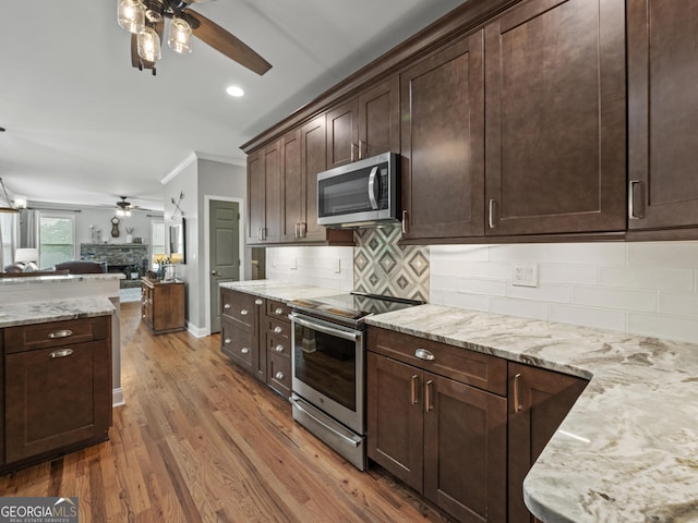 302 Thornhill Cir, Jefferson, GA 30549 - kitchen with stainless steel appliances, a ceiling fan, open floor plan, a fireplace, and ornamental molding