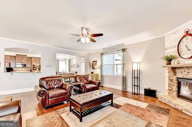 2325 Lake Cove Ct, Buford, GA 30519 - living room featuring ceiling fan, wood finished floors, ornamental molding, and a stone fireplace