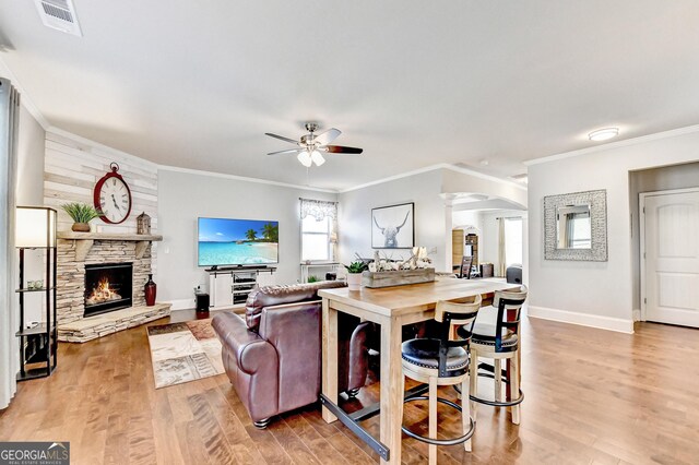 2325 Lake Cove Ct, Buford, GA 30519 - living room with arched walkways, ceiling fan, ornamental molding, light wood finished floors, and a fireplace