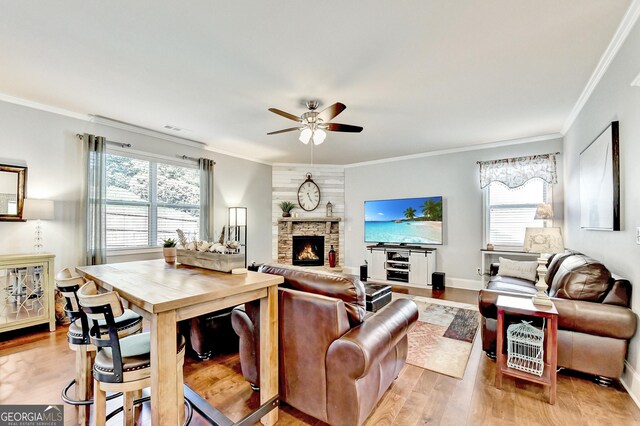 2325 Lake Cove Ct, Buford, GA 30519 - living room featuring a ceiling fan, light wood-style floors, healthy amount of natural light, and crown molding