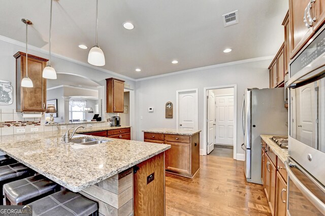 2325 Lake Cove Ct, Buford, GA 30519 - kitchen with decorative columns, brown cabinetry, a center island, arched walkways, and recessed lighting