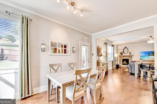 2325 Lake Cove Ct, Buford, GA 30519 - dining room with a fireplace, light wood-type flooring, crown molding, and ceiling fan