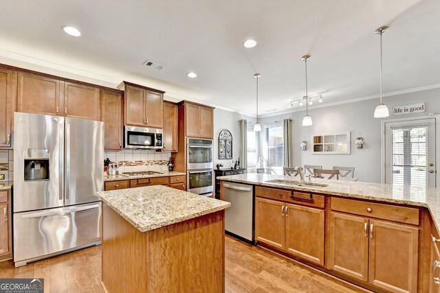 2325 Lake Cove Ct, Buford, GA 30519 - kitchen with appliances with stainless steel finishes, crown molding, healthy amount of natural light, a center island, and light stone countertops