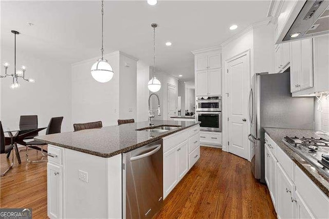 4089 Thorndale Ln Unit 13, Smyrna, GA 30080 - kitchen featuring stainless steel appliances, range hood, a center island with sink, dark wood-style flooring, and white cabinetry
