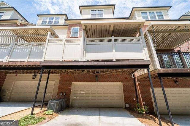 4089 Thorndale Ln Unit 13, Smyrna, GA 30080 - rear view of property with brick siding, a garage, a balcony, and driveway