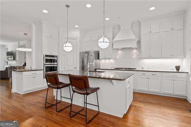4089 Thorndale Ln Unit 13, Smyrna, GA 30080 - kitchen featuring premium range hood, appliances with stainless steel finishes, decorative backsplash, wood finished floors, and recessed lighting