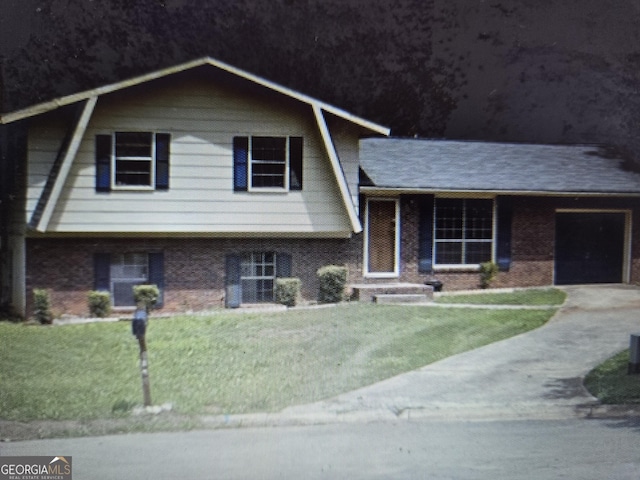 8778 Homewood Ct, Riverdale, GA 30274 - split level home with brick siding, a front lawn, an attached garage, and concrete driveway