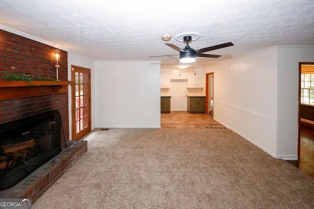 2202 Springdale Dr, Snellville, GA 30078 - unfurnished living room featuring a ceiling fan, light carpet, a fireplace, a textured ceiling, and ornamental molding
