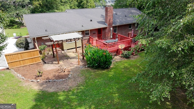 2202 Springdale Dr, Snellville, GA 30078 - rear view of house featuring a deck, brick siding, a lawn, and a patio