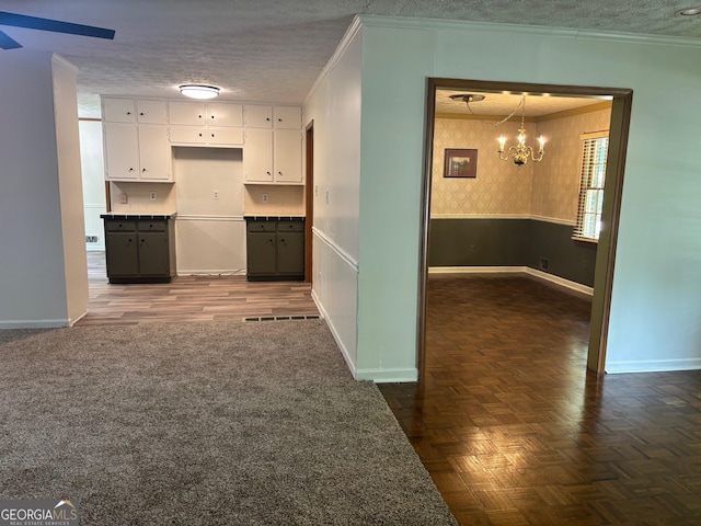 2202 Springdale Dr, Snellville, GA 30078 - kitchen with a chandelier, ornamental molding, wallpapered walls, white cabinetry, and ceiling fan