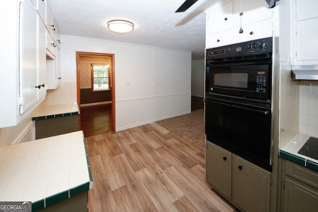 2202 Springdale Dr, Snellville, GA 30078 - kitchen featuring tile countertops, light wood-type flooring, ornamental molding, white cabinets, and tasteful backsplash