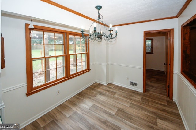 2202 Springdale Dr, Snellville, GA 30078 - unfurnished dining area featuring a chandelier, wood finished floors, and crown molding