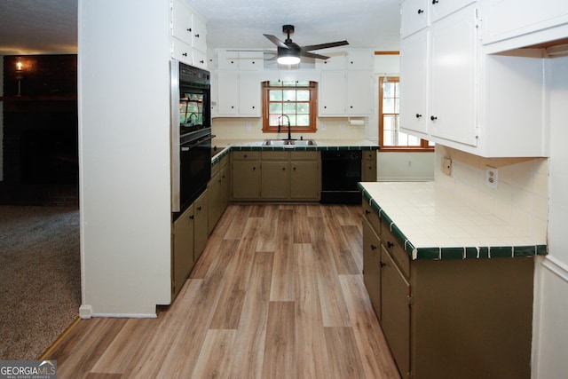 2202 Springdale Dr, Snellville, GA 30078 - kitchen featuring tile countertops, black appliances, ceiling fan, light wood-type flooring, and white cabinetry