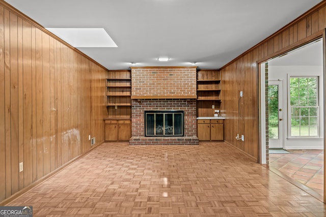 175 Cedar Creek Dr, Athens, GA 30605 - unfurnished living room featuring wood walls, a brick fireplace, and crown molding