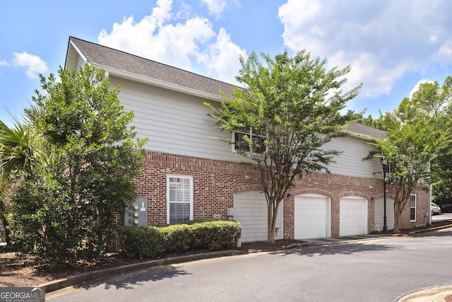 300 Brickworks Cir NE # 302, Atlanta, GA 30307 - view of side of property featuring brick siding, a garage, and driveway