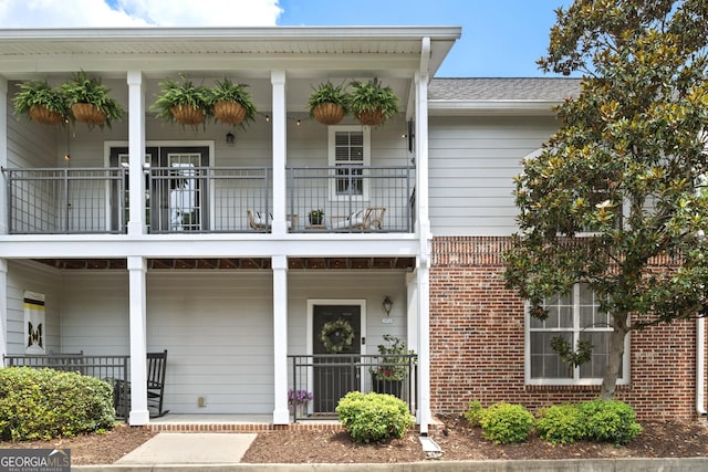 300 Brickworks Cir NE # 302, Atlanta, GA 30307 - view of front of home featuring brick siding, a balcony, covered porch, and roof with shingles