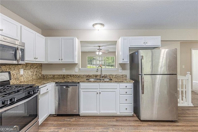7420 Bristol, Douglasville, GA 30134 - kitchen featuring appliances with stainless steel finishes, wood finished floors, white cabinets, dark stone countertops, and a ceiling fan