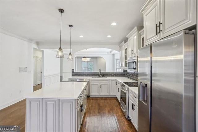 2108 Main St NW, Atlanta, GA 30318 - kitchen featuring appliances with stainless steel finishes, arched walkways, light countertops, tasteful backsplash, and dark wood-style floors