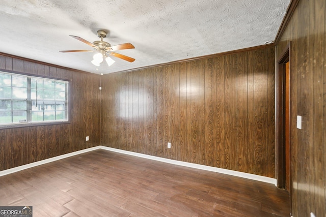 1517 Indian Forest Trl, Stone Mountain, GA 30083 - spare room featuring a ceiling fan, a textured ceiling, wood finished floors, and wooden walls