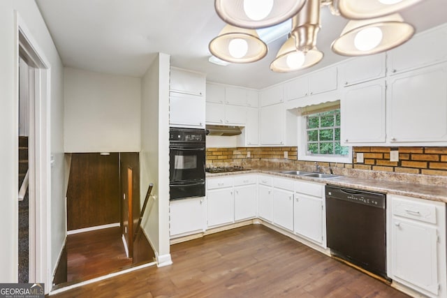 1517 Indian Forest Trl, Stone Mountain, GA 30083 - kitchen with black appliances, backsplash, under cabinet range hood, dark wood-style flooring, and white cabinetry