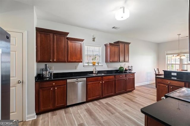 1147 Scenic Park Trl, Lawrenceville, GA 30046 - kitchen with appliances with stainless steel finishes, dark countertops, light wood finished floors, decorative light fixtures, and a chandelier