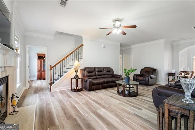 1147 Scenic Park Trl, Lawrenceville, GA 30046 - living area featuring a ceiling fan, light wood-style floors, arched walkways, stairs, and a high end fireplace