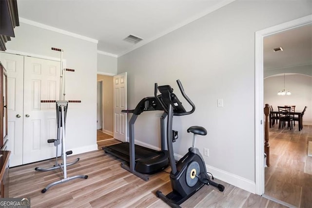 1147 Scenic Park Trl, Lawrenceville, GA 30046 - exercise area with arched walkways, wood finished floors, crown molding, and a chandelier