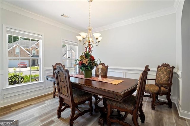 1147 Scenic Park Trl, Lawrenceville, GA 30046 - dining space featuring a chandelier, light wood finished floors, a decorative wall, plenty of natural light, and crown molding