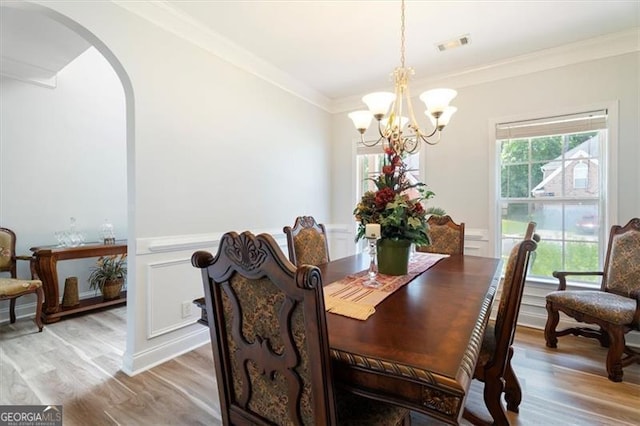 1147 Scenic Park Trl, Lawrenceville, GA 30046 - dining space featuring arched walkways, a chandelier, light wood-style flooring, and ornamental molding