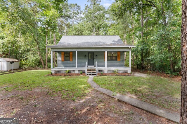 144 Winding Way, Statesboro, GA 30461 - view of front of house with a porch, a shed, a front lawn, and a shingled roof