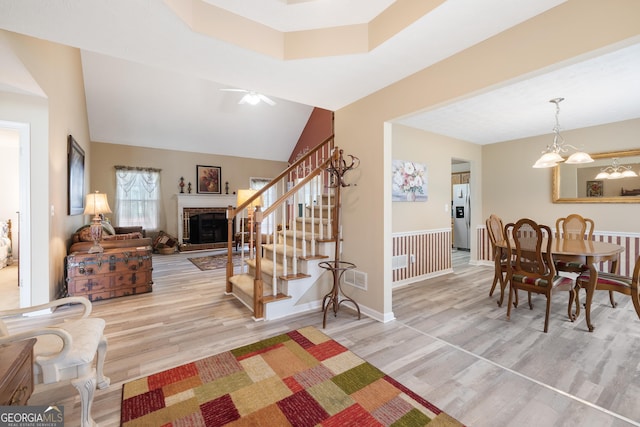 20 Knollwood Pl, Covington, GA 30014 - dining room with wood finished floors, a fireplace, stairs, a chandelier, and a ceiling fan