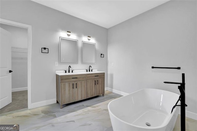 5719 Calm Vly, Flowery Branch, GA 30542 - bathroom with double vanity, a freestanding tub, a spacious closet, and marble finish floors
