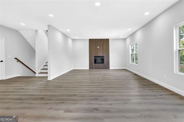 5719 Calm Vly, Flowery Branch, GA 30542 - unfurnished living room with plenty of natural light, wood finished floors, recessed lighting, and a fireplace