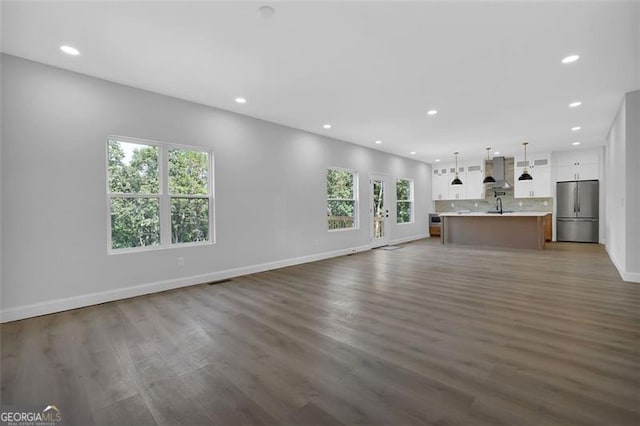 5719 Calm Vly, Flowery Branch, GA 30542 - unfurnished living room with recessed lighting and dark wood-type flooring