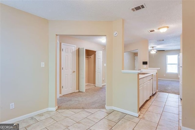 179 Glynn Addy, Stockbridge, GA 30281 - kitchen featuring light carpet, a textured ceiling, white appliances, light countertops, and light tile patterned flooring