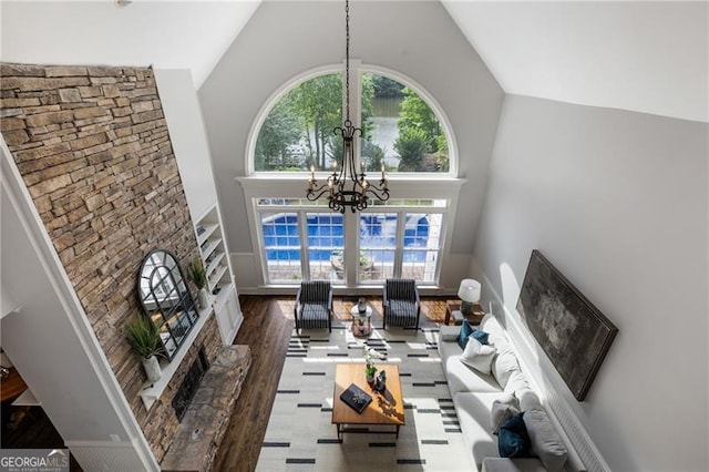 13520 Providence Lk, Alpharetta, GA 30004 - living room featuring high vaulted ceiling, a chandelier, a fireplace with raised hearth, and wood finished floors