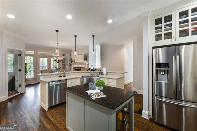 13520 Providence Lk, Alpharetta, GA 30004 - kitchen with stainless steel appliances, a center island with sink, dark wood-style floors, light stone countertops, and white cabinets