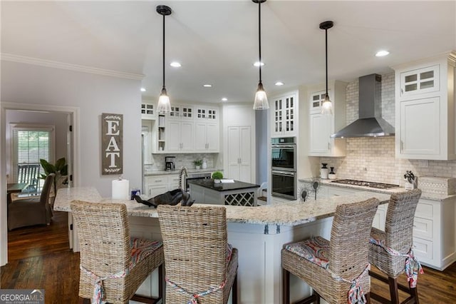 13520 Providence Lk, Alpharetta, GA 30004 - kitchen with wall chimney range hood, a spacious island, appliances with stainless steel finishes, crown molding, and tasteful backsplash
