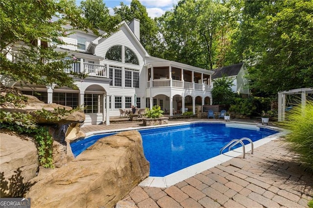 13520 Providence Lk, Alpharetta, GA 30004 - back of house with a balcony, a patio area, a chimney, and an outdoor pool