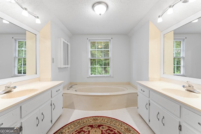 829 Bev Ct, Lawrenceville, GA 30046 - bathroom featuring two vanities, plenty of natural light, and a textured ceiling