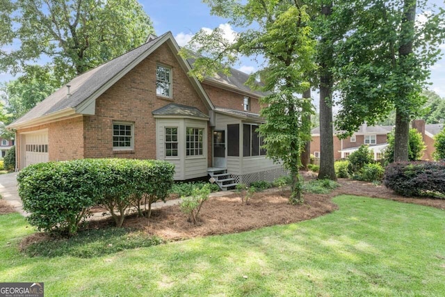 829 Bev Ct, Lawrenceville, GA 30046 - rear view of house featuring a garage, a sunroom, brick siding, a yard, and a shingled roof