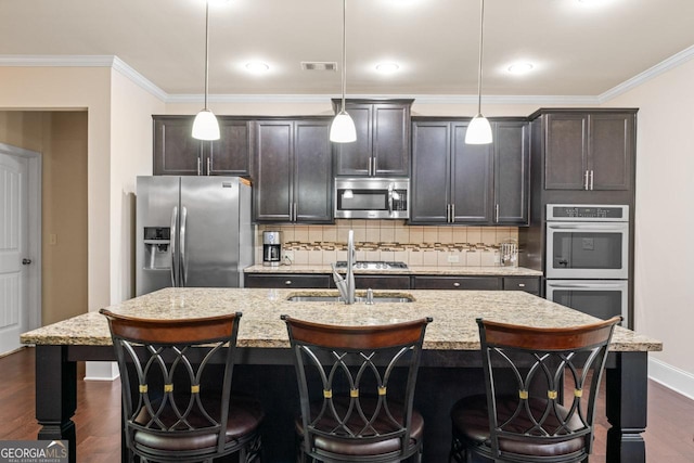 2844 Bluestone Dr SW, South Fulton, GA 30331 - kitchen featuring stainless steel appliances, a center island with sink, dark wood-type flooring, backsplash, and a kitchen bar